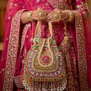 Pink and gold beaded bridal potli bag for wedding carried by Indian bride