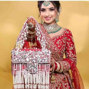 Red pearl embellished bridal bag for Indian bride with traditional lehenga