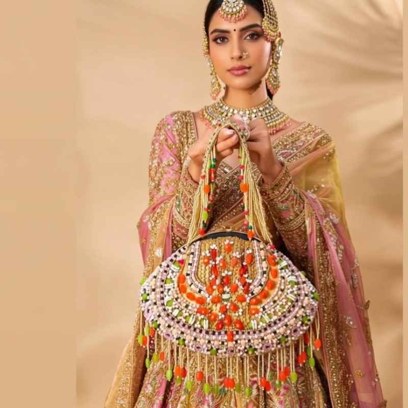 Luxury beaded bridal bag for reception with colorful stones and pearl fringe carried by bride”